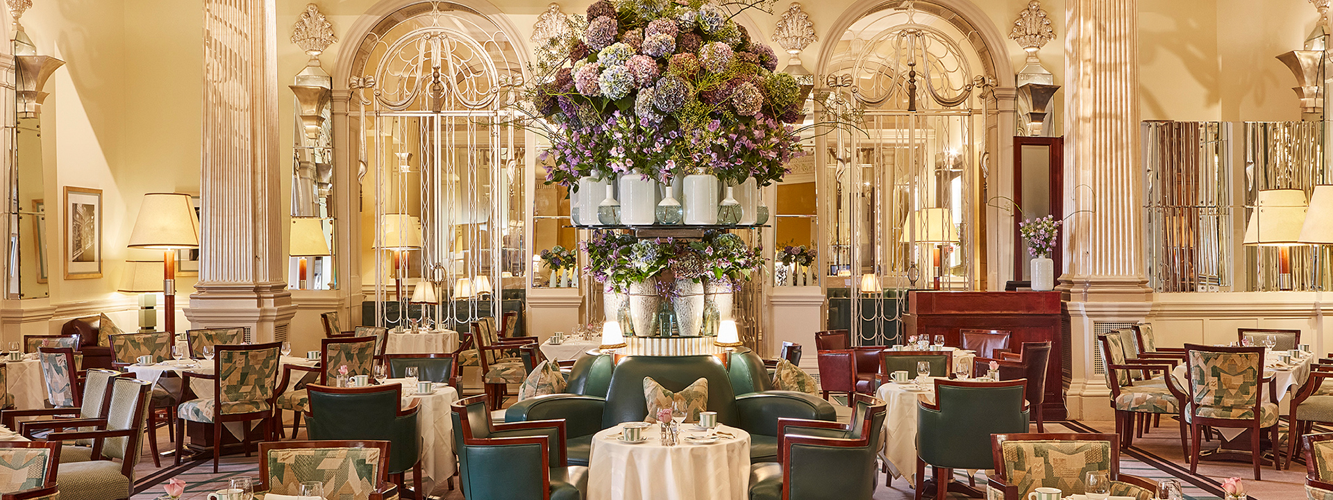 Claridge's Foyer and Reading Room - empty room with tables and chairs and flowers in the centre.